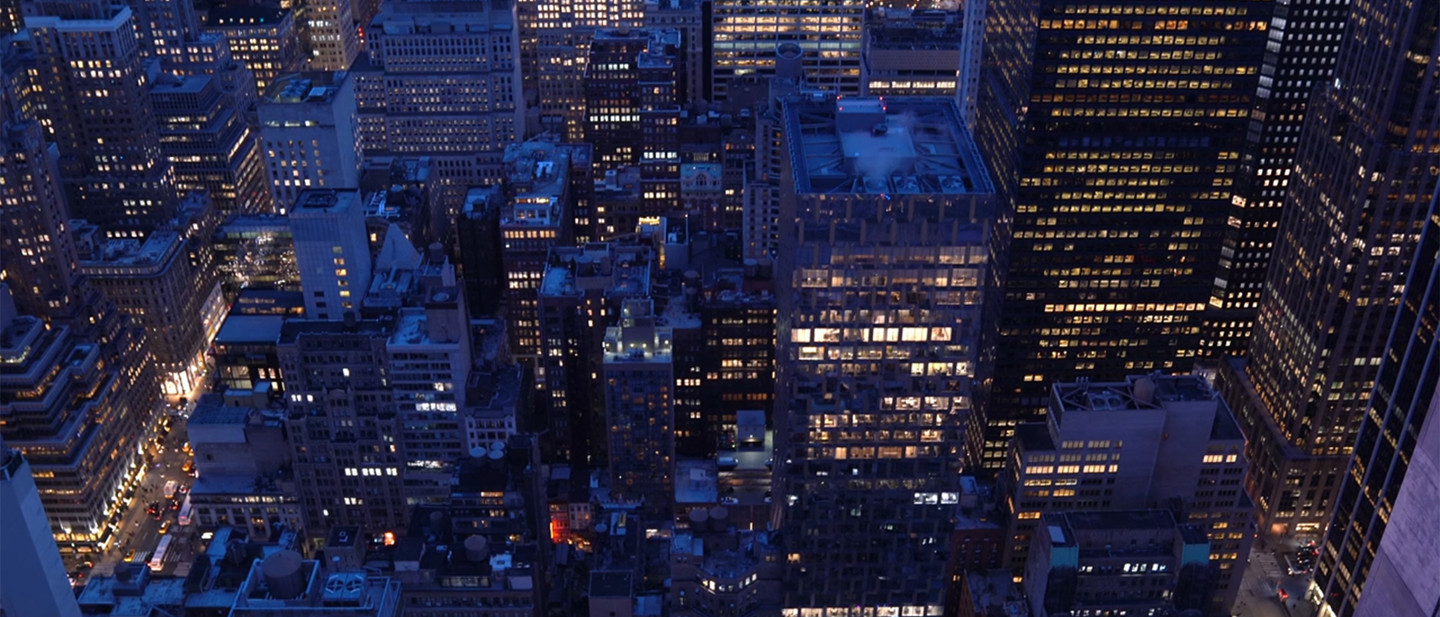 Aerial view of city buildings and lights at night